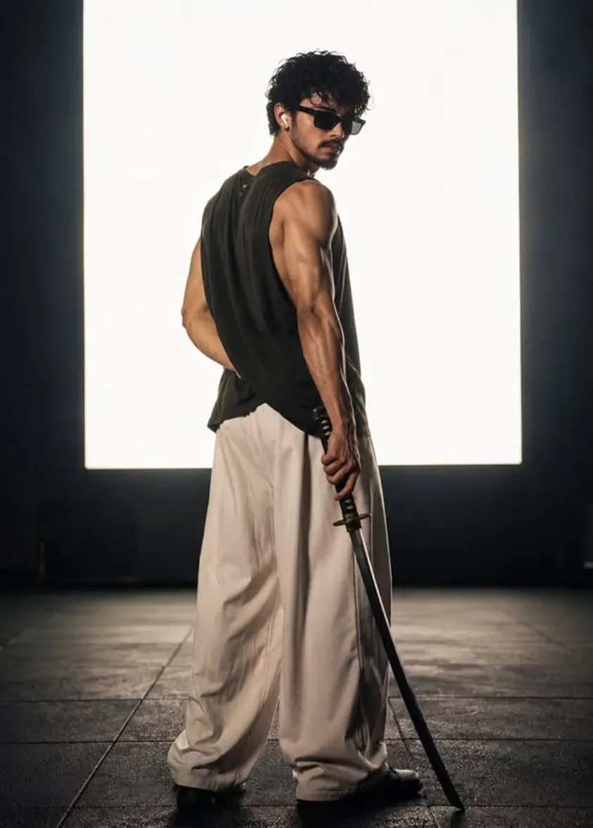 Cinematic portrait of a muscular man with a katana standing against a bright backlit square panel in a dark minimalist room.
